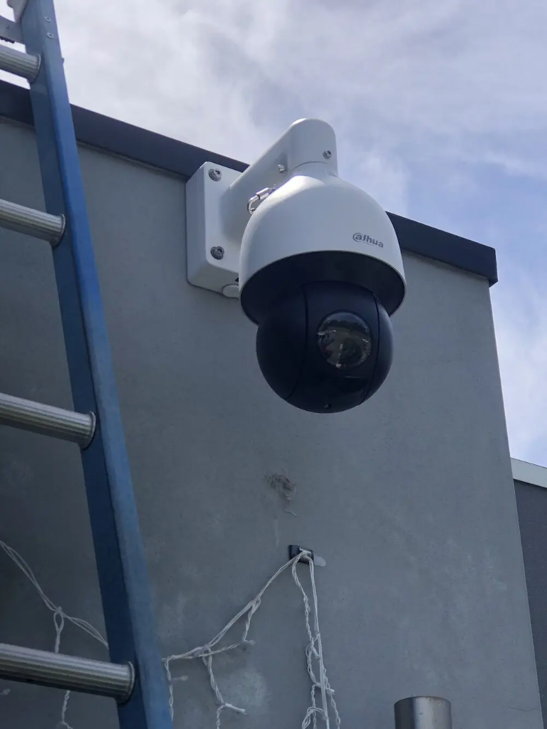 Dahua PTZ security camera mounted on wall bracket with concealed weatherproof cabling on Logan home